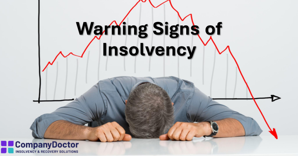 a man, head down on desk stressed about his insolvent company